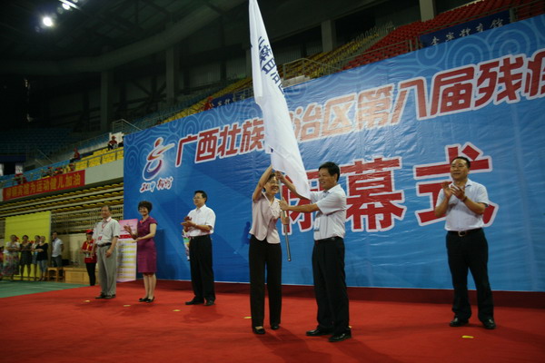图为运动会组委会主任、自治区残联理事长边疆将运动会会旗交给下一届残运会举办地桂林市副市长巫家世手中